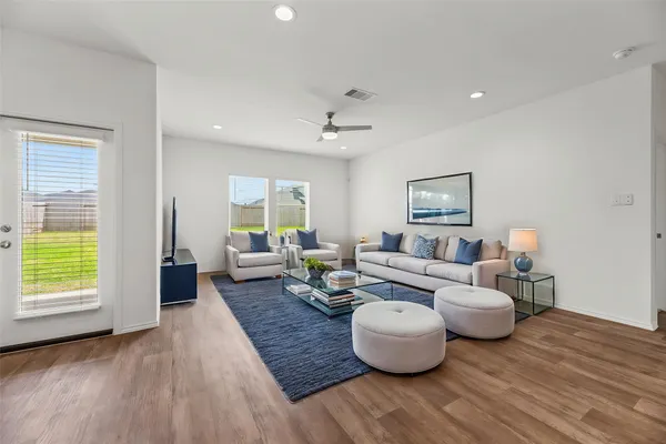 a living room with furniture and a wooden floor