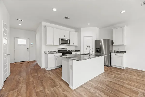 a kitchen with white cabinets and stainless steel appliances