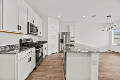 a kitchen with stainless steel appliances granite countertop a sink and a stove