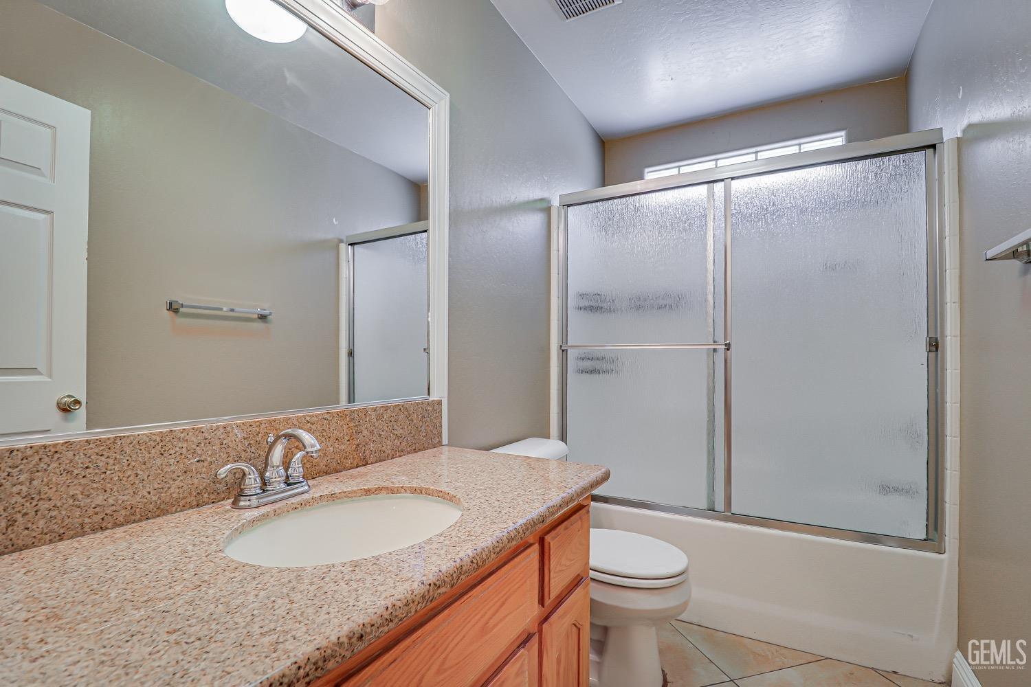 Undisclosed Address Bakersfield, CA 93312 - Photo 16 of 28 a bathroom with a granite countertop sink toilet and shower