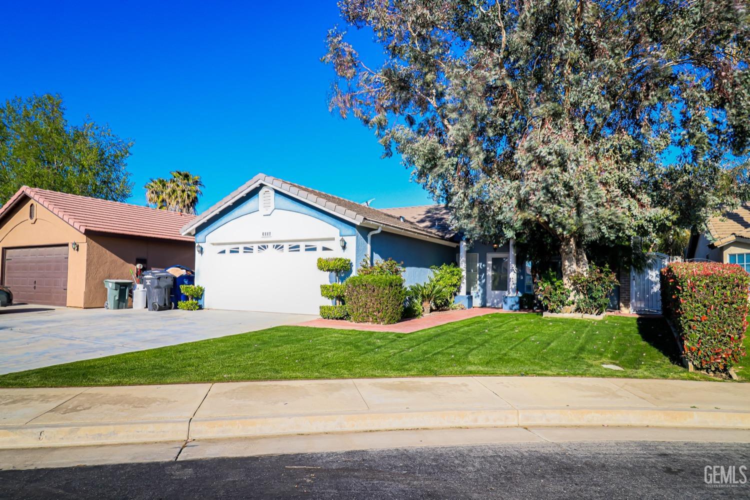 Undisclosed Address Bakersfield, CA 93312 - Photo 3 of 28 a front view of a house with a yard and garage