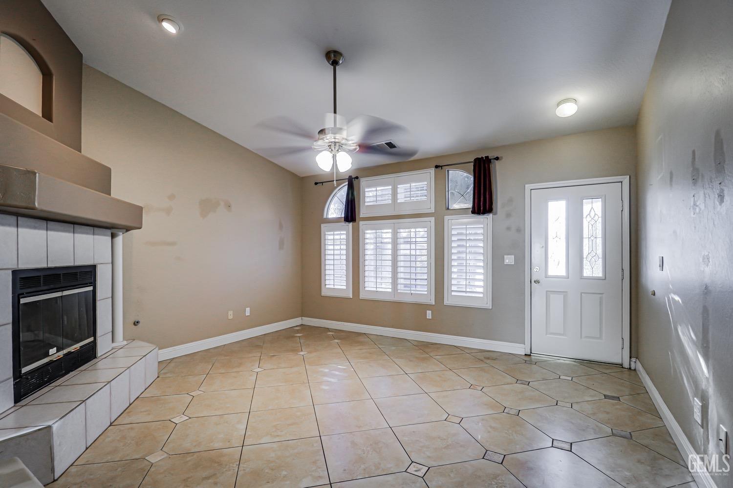 Undisclosed Address Bakersfield, CA 93312 - Photo 7 of 28 a view of an empty room with a fireplace and a window