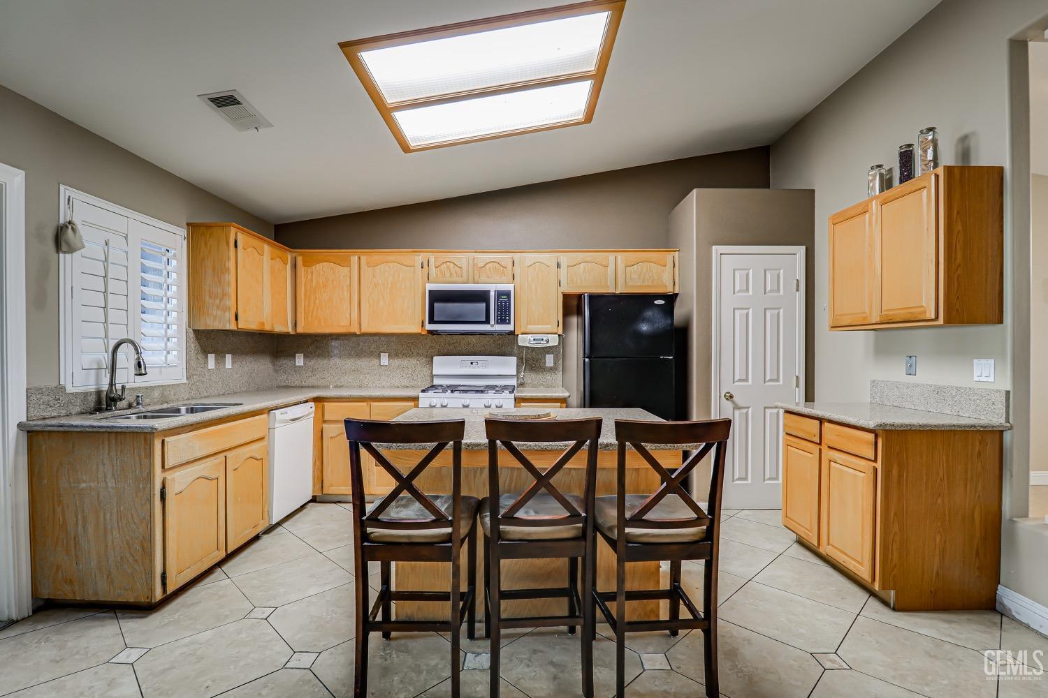 Undisclosed Address Bakersfield, CA 93312 - Photo 9 of 28 a kitchen with stainless steel appliances granite countertop a stove a sink dishwasher and a refrigerator with wooden cabinets