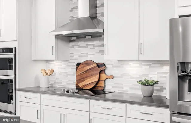 a kitchen with stainless steel appliances granite countertop a sink and a refrigerator