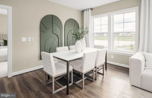 a kitchen with stainless steel appliances a dining table chairs refrigerator and sink