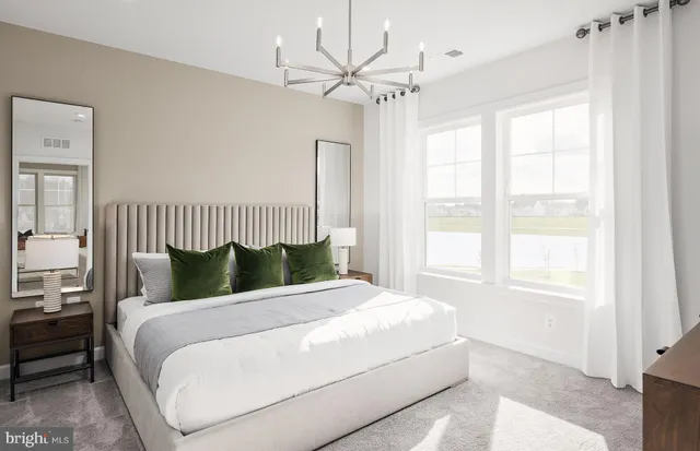 a living room with furniture a large window wooden floor and a rug