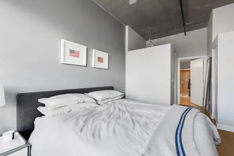 a bedroom with a bed and a painting on the wall
