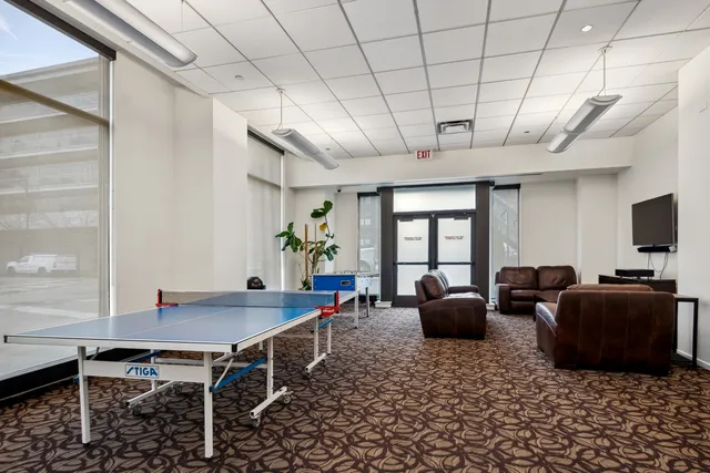 a living room with furniture a window and gym equipment