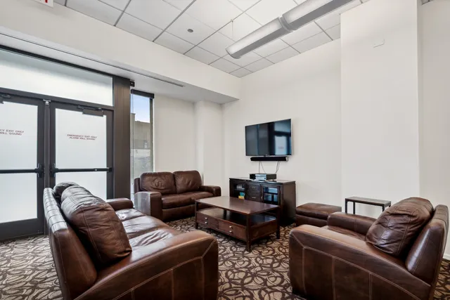 a living room with furniture a flat screen tv and a window