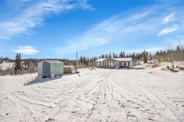 a view of a house with a yard covered in snow