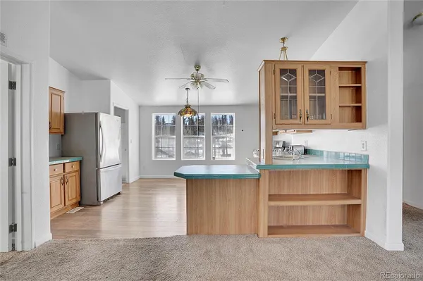 a kitchen with granite countertop a sink cabinets stainless steel appliances and a window