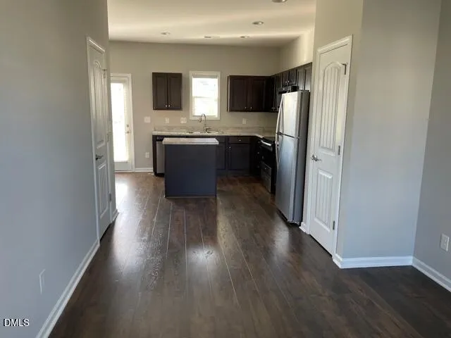 a kitchen with a sink a microwave a refrigerator and cabinets