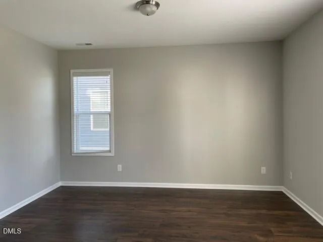 a view of a kitchen with a refrigerator and wooden floor