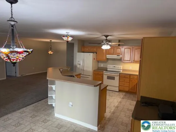 a kitchen with kitchen island a chandelier and stove