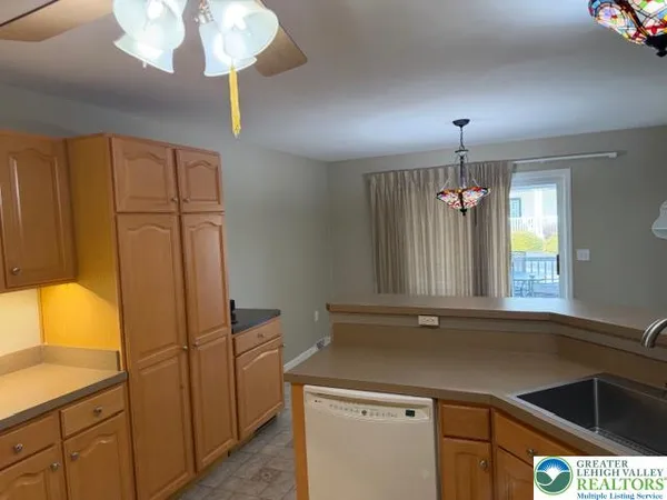 a kitchen that has a lot of cabinets and wooden floor