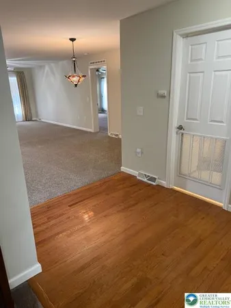 an empty room with wooden floor and mirror