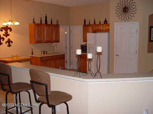 2933 Turning Leaf Lane Jacksonville, FL 32221 - Photo 3 of 15 a kitchen with stainless steel appliances kitchen island granite countertop a refrigerator and a stove top oven