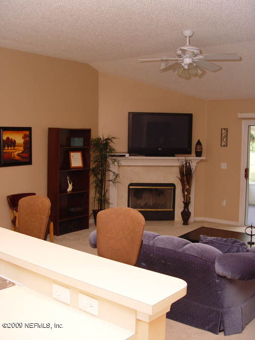 2933 Turning Leaf Lane Jacksonville, FL 32221 - Photo 6 of 15 a living room with furniture a flat screen tv and a fireplace
