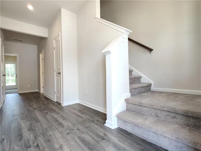 a view of kitchen with kitchen island a sink wooden floor and a refrigerator
