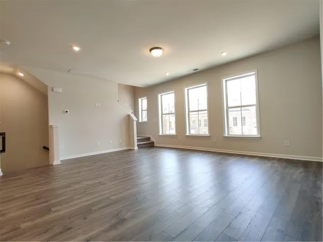 a open kitchen with white cabinets stainless steel appliances and wooden floor