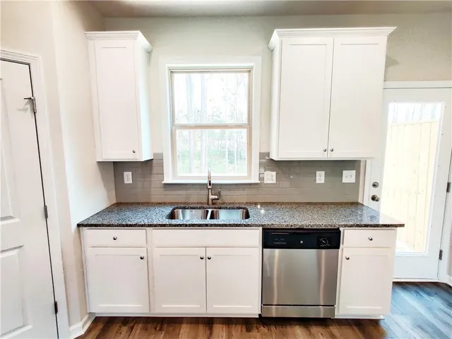 a kitchen with granite countertop a sink and a stove