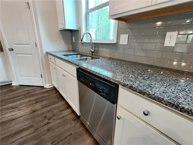 a kitchen with stainless steel appliances granite countertop a stove microwave and sink