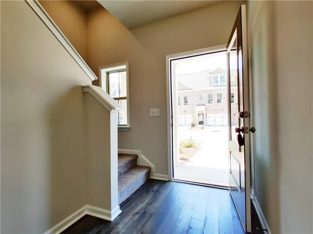 a view of a hallway with wooden floor and staircase