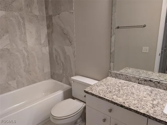 a bathroom with a granite countertop sink toilet and bathtub