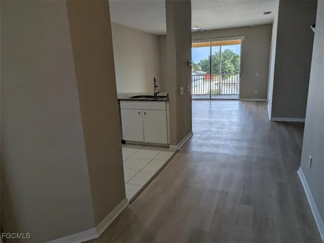 a view of a kitchen from the hallway with wooden floor