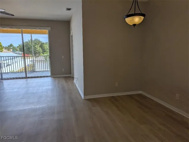 a view of a room with wooden floor and a window