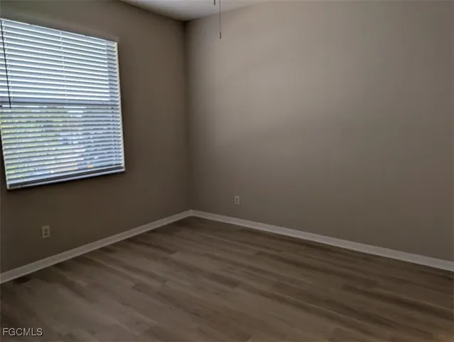 an empty room with wooden floor and a window