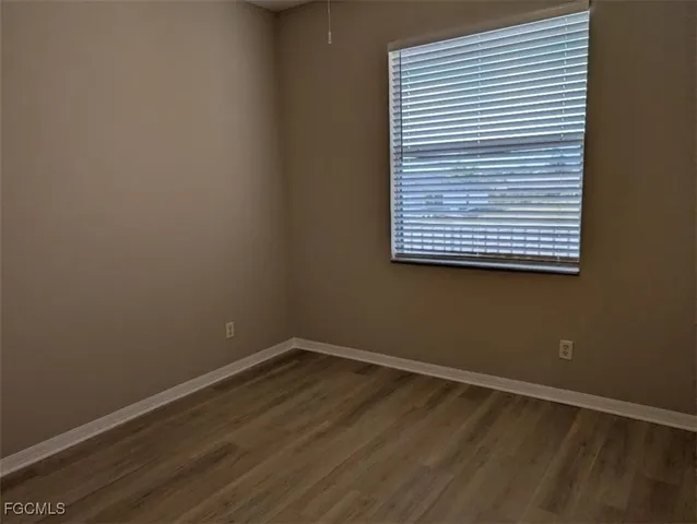 a view of a small space with wooden floor and a window