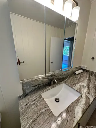 a bathroom with a granite countertop sink and a mirror
