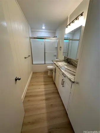 a kitchen with granite countertop a sink and wooden floor