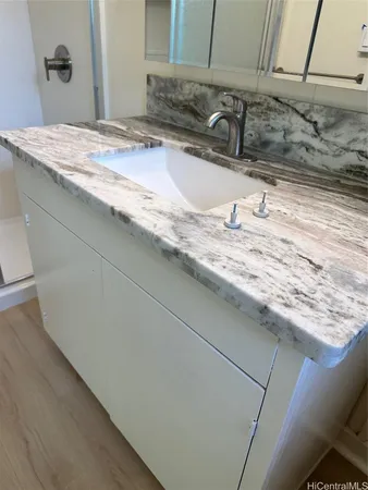 a bathroom with a granite countertop sink and a mirror