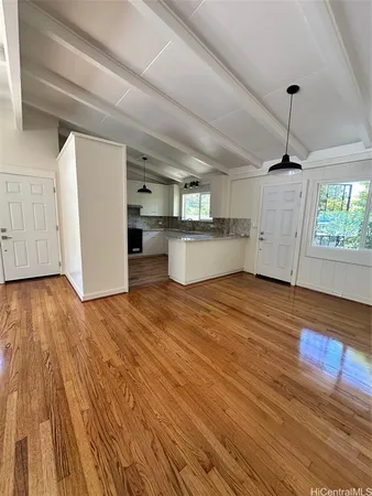 a view of empty room with wooden floor and window