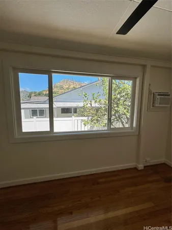 a view of a room with wooden floor and a window