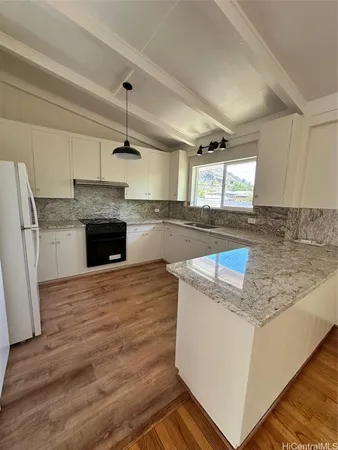 a kitchen with kitchen island a sink stainless steel appliances granite countertop a stove and a sink