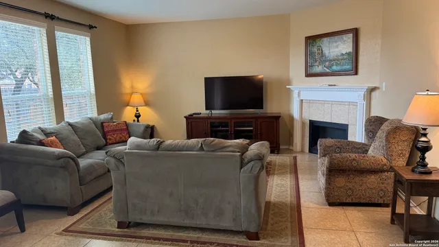 a living room with furniture a flat screen tv and a fireplace