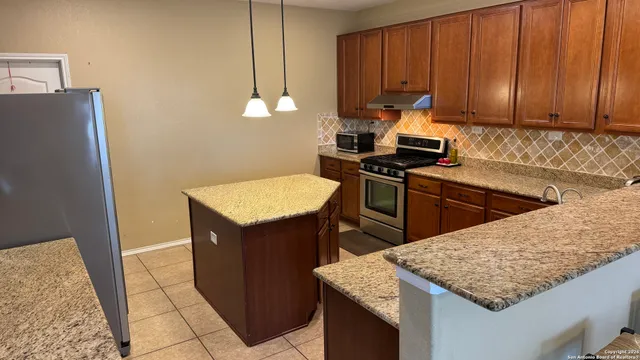 a kitchen with a sink a stove and a refrigerator