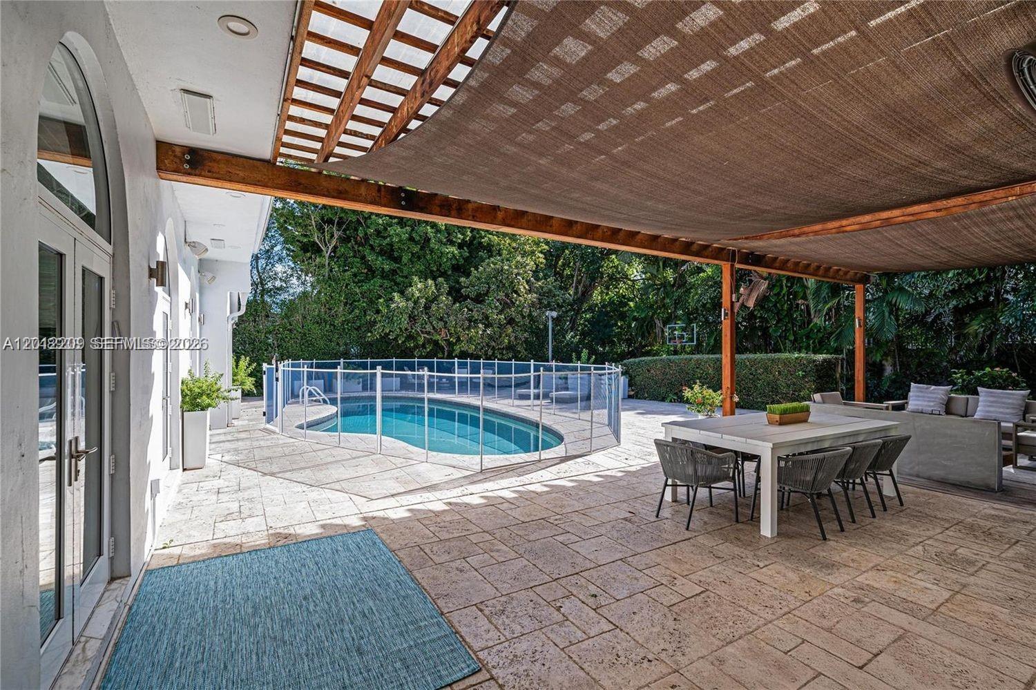 530 Sabal Palm Road Miami, FL 33137 - Photo 16 of 30 a view of a patio with a table chairs and a backyard