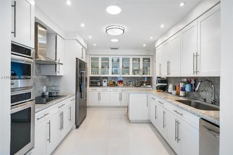 a kitchen with granite countertop white cabinets and white appliances