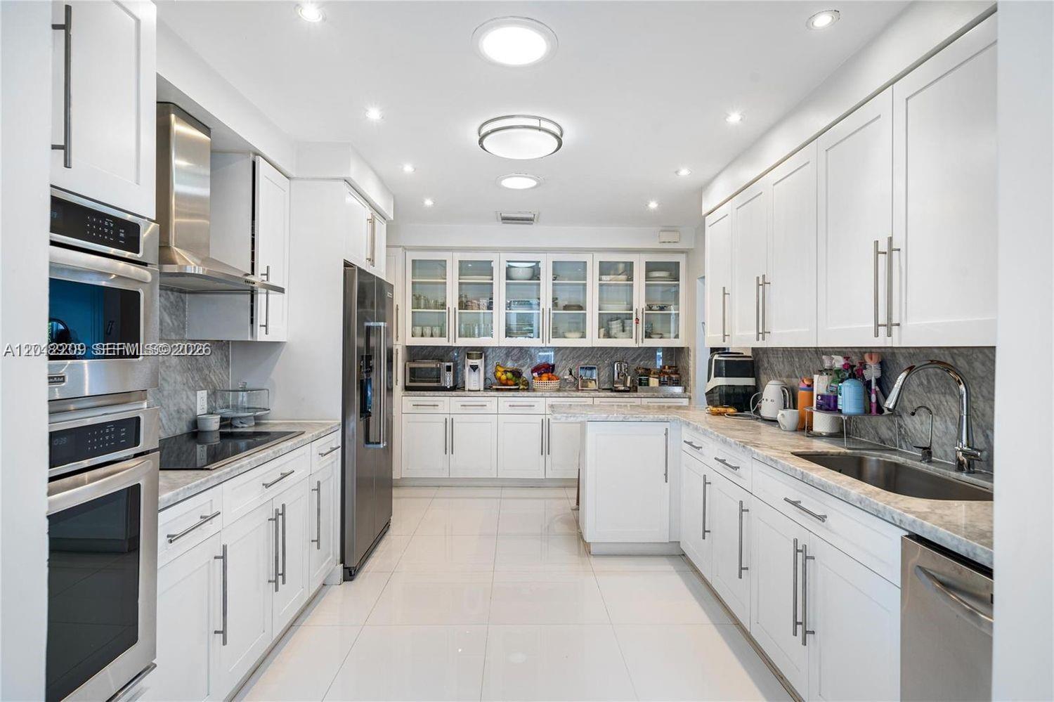 530 Sabal Palm Road Miami, FL 33137 - Photo 8 of 30 a kitchen with granite countertop white cabinets and white appliances