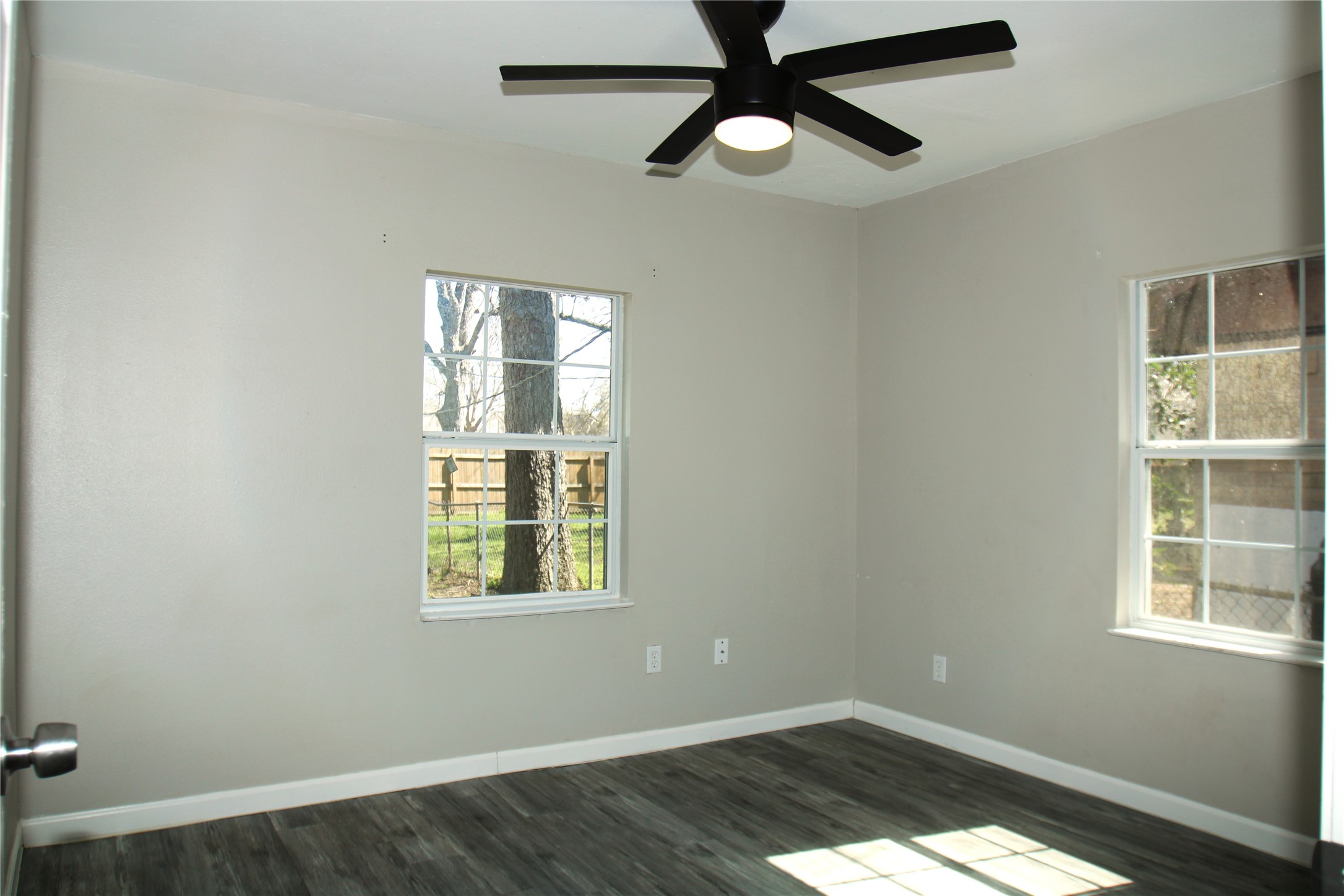 817 South Morgan Street Angleton, TX 77515 - Photo 11 of 16 an empty room with wooden floor windows and fan