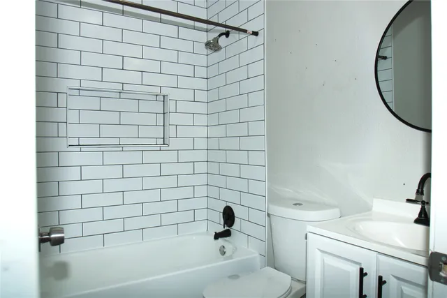 an empty room with wooden floor windows and fan