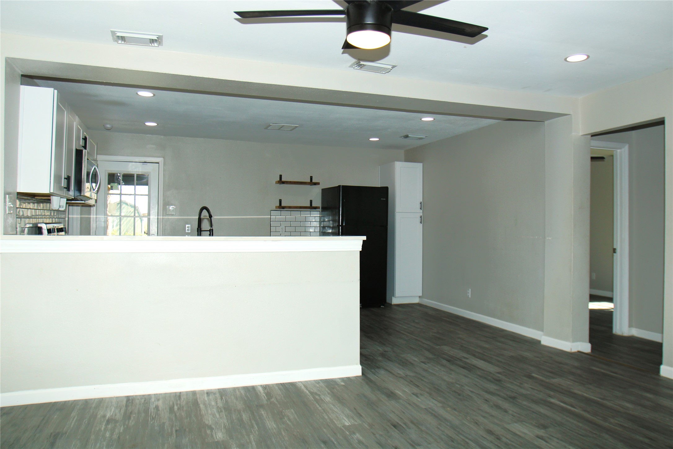 817 South Morgan Street Angleton, TX 77515 - Photo 4 of 16 a room with kitchen island a sink and wooden floor