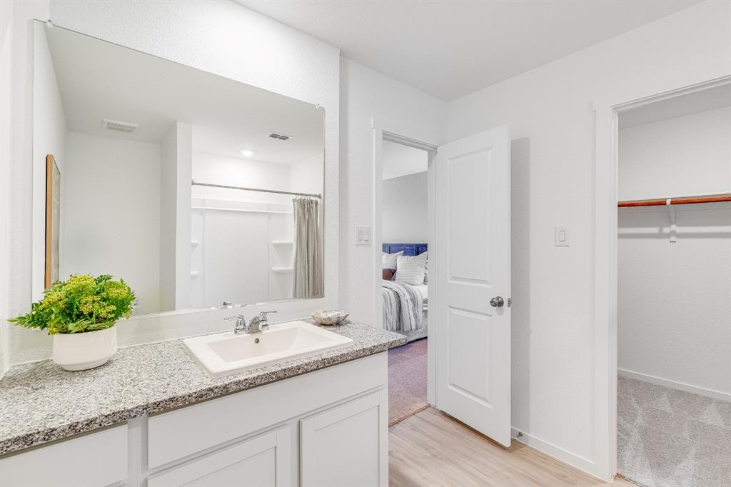 1287 Maple Street Wilmer, TX 75172 - Photo 16 of 22 a bathroom with a granite countertop sink and a mirror