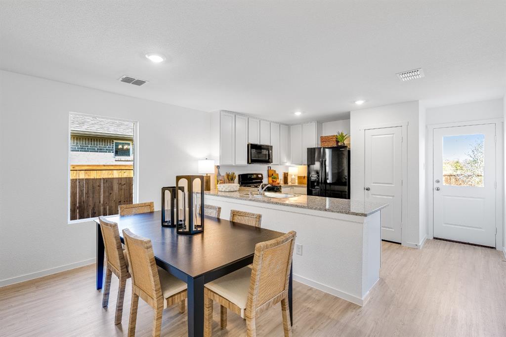 1287 Maple Street Wilmer, TX 75172 - Photo 7 of 22 a kitchen with a dining table chairs and refrigerator