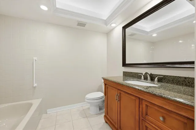 a bathroom with a granite countertop sink a toilet and a large mirror