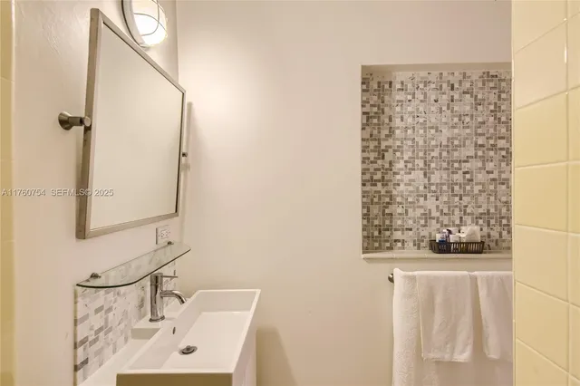 a bathroom with a sink a mirror and shower